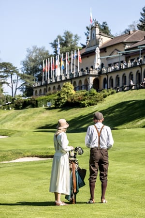 Two Hickory Masters participants wearing official event knitwear posing together on the golf course.
