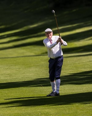 Hickory golfer watching the flight of the ball after an approach shot on the fairway.