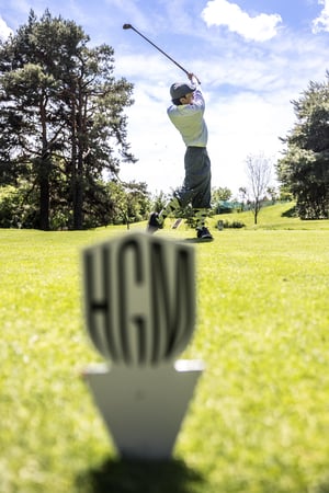 Hickory golfer at the top of the backswing preparing to drive from the tee.