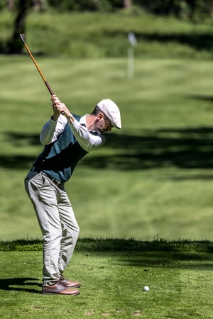 Hickory golfer at the top of the backswing preparing to strike the ball from the fairway during the tournament