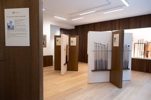 Exhibition area with panels displaying historical information and collections of antique golf clubs mounted on elegant showcases.