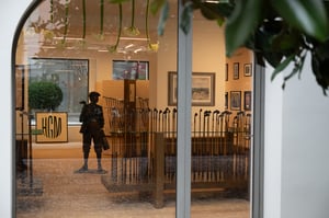 Exterior view through a window into the Hickory Golf Masters Museum, showing vintage golf clubs, artwork, and a bronze statue.